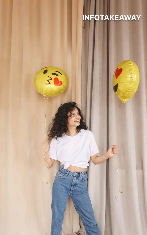 Woman holding balloons with emoji shapes